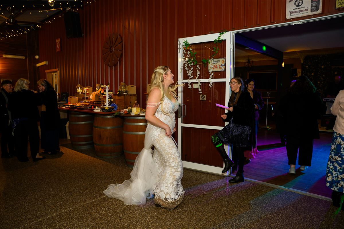 Bride laughing as she enters the barn reception
