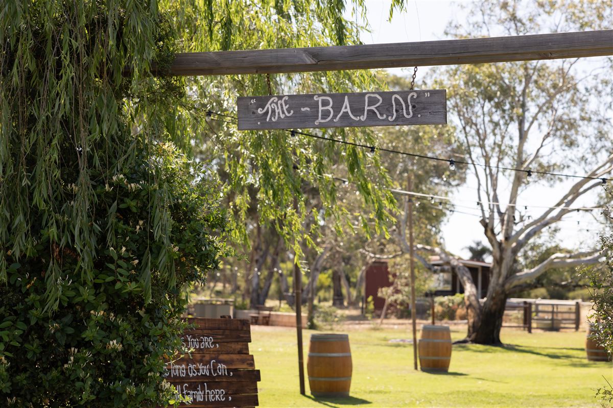 Timber The Barn entry sign with barrels and festoon